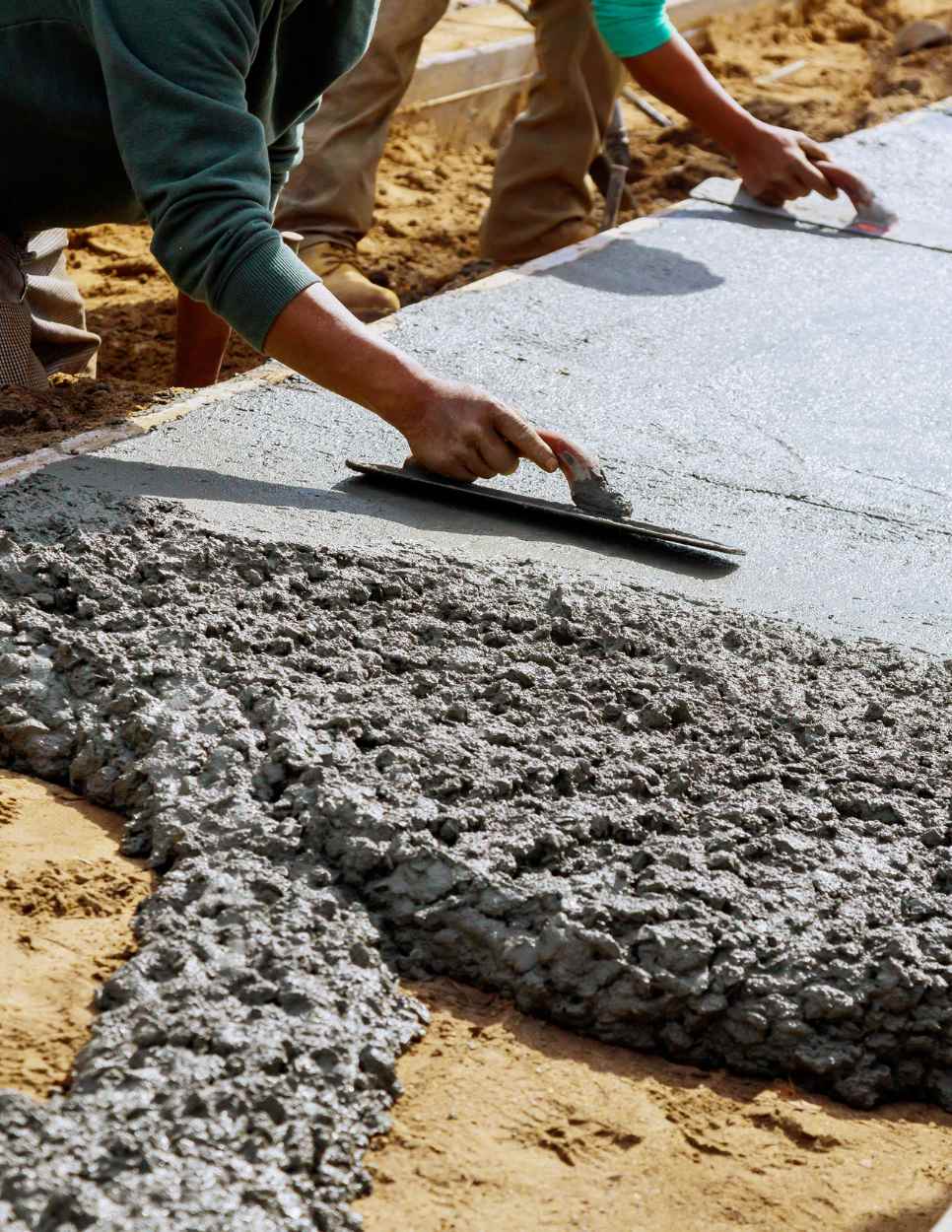 Man smoothing cement sidewalk