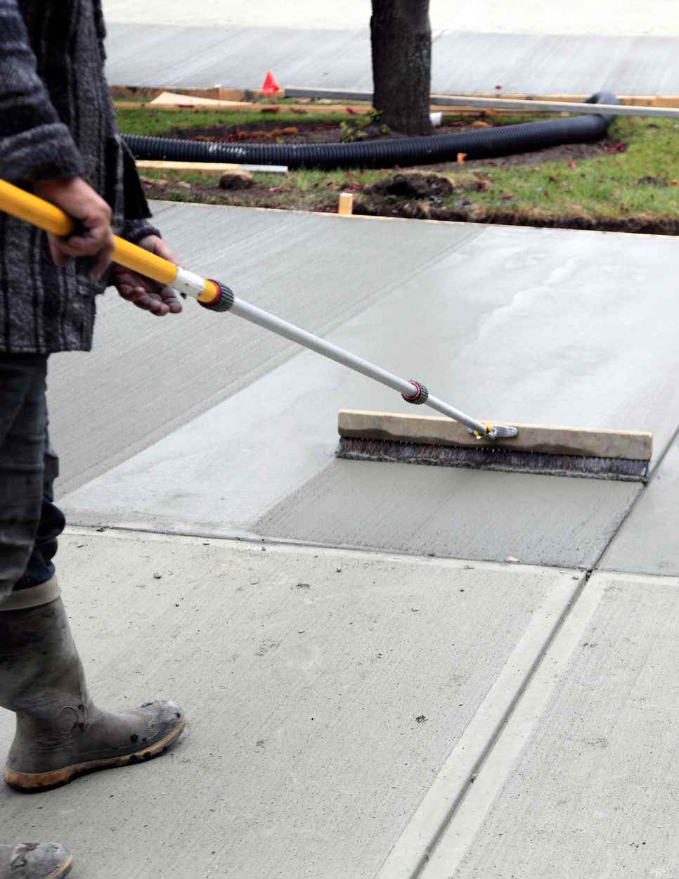 Man smoothing cement driveway